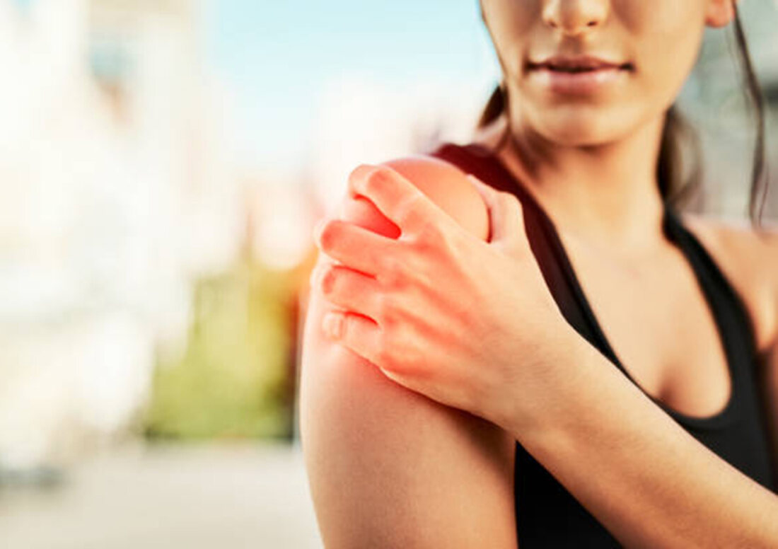 A patient holding a painful shoulder
